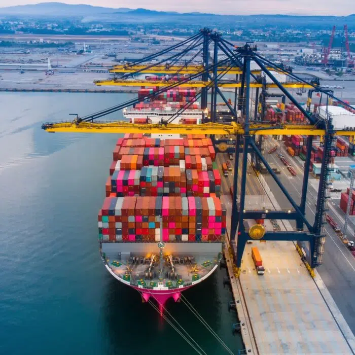 crane loanding cargo container to container ship in the international terminal yard port